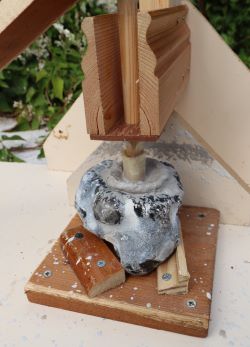 A bow-drill in the process of drilling an aperture in a flint nodule using a hollow bone drill bit with quartzite grit as an abrasive.