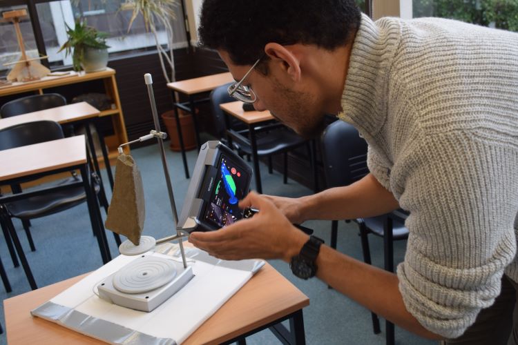 Yousef Konswah undertaking a 3-D laser scan or an ogham stone in the Discipline of Archaeology