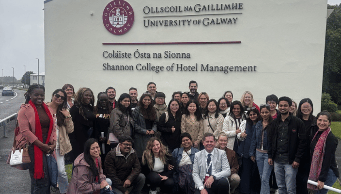 international agent visit. agents smiling outside college building 