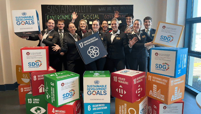 Students and staff in the sustainability committee holding boxes with our sustainability goals